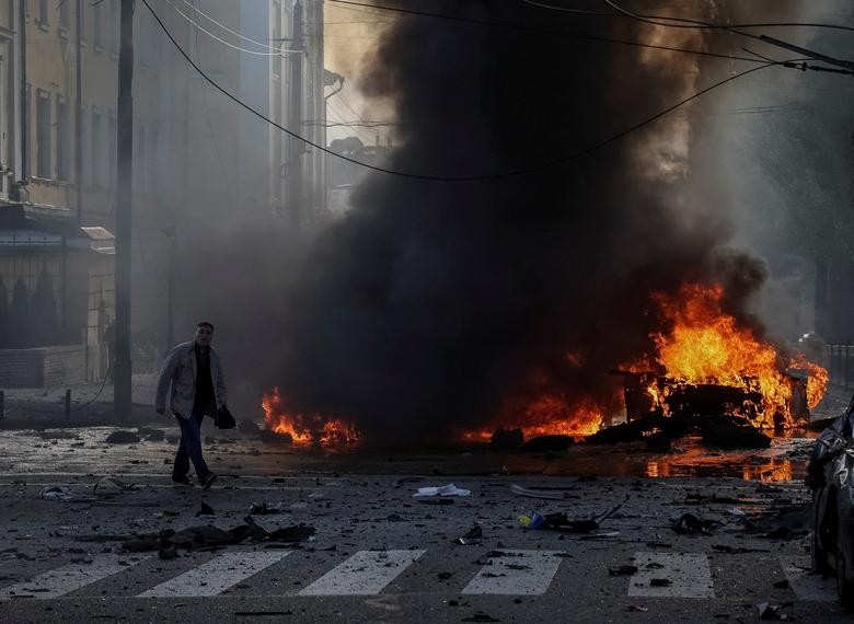 Người lái xe đi gần chiếc xe bị cháy của mình sau cuộc tấn công của quân đội Nga ở miền trung Kiev, Ukraine, ngày 10/10. (Nguồn: Reuters)