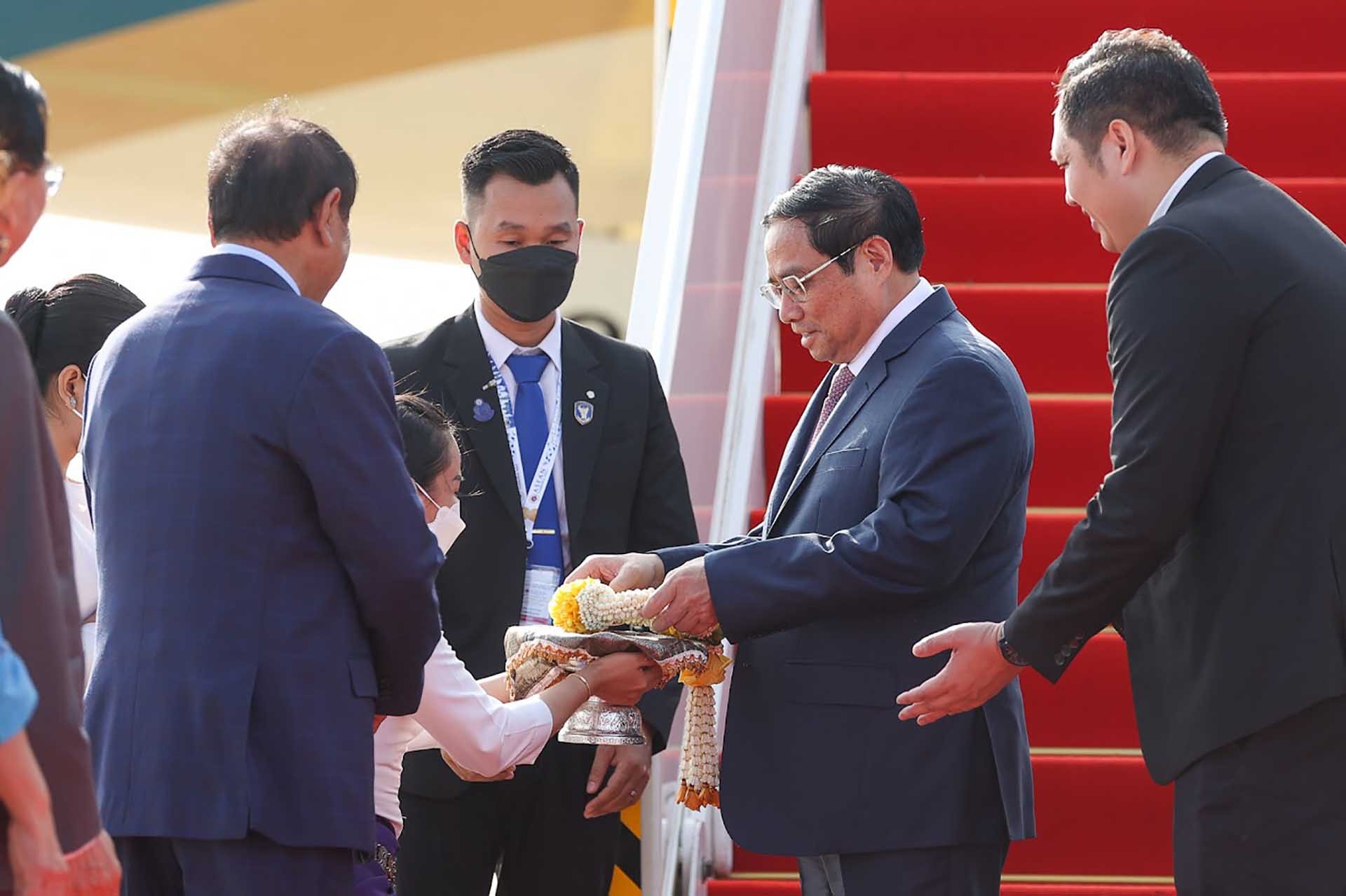 Thủ tướng Phạm Minh Chính nhận hoa chúc mừng tại sân bay quốc tế Phnom Penh. (Nguồn: VGP)