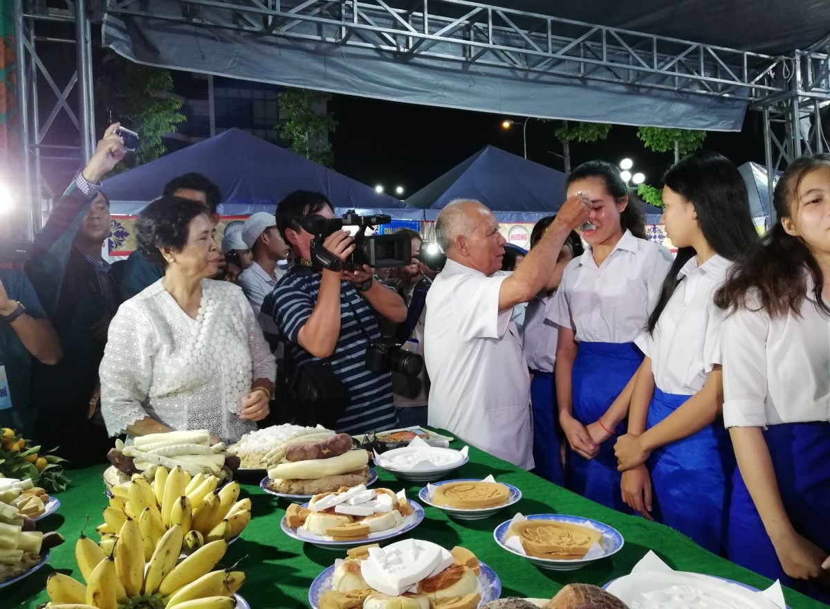 Phục dựng Lễ cúng trăng phục vụ đồng bào dân tộc Khmer trong dịp Lễ hội Oóc Om Bóc, chủ lễ “Đút cốm dẹp” cho các em nhỏ với lời chúc mau ăn chóng lớn và vỗ nhẹ vào lưng vài lần đồng thời hỏi nhỏ những điều các em mong muốn. (Ảnh: Phương Nghi)