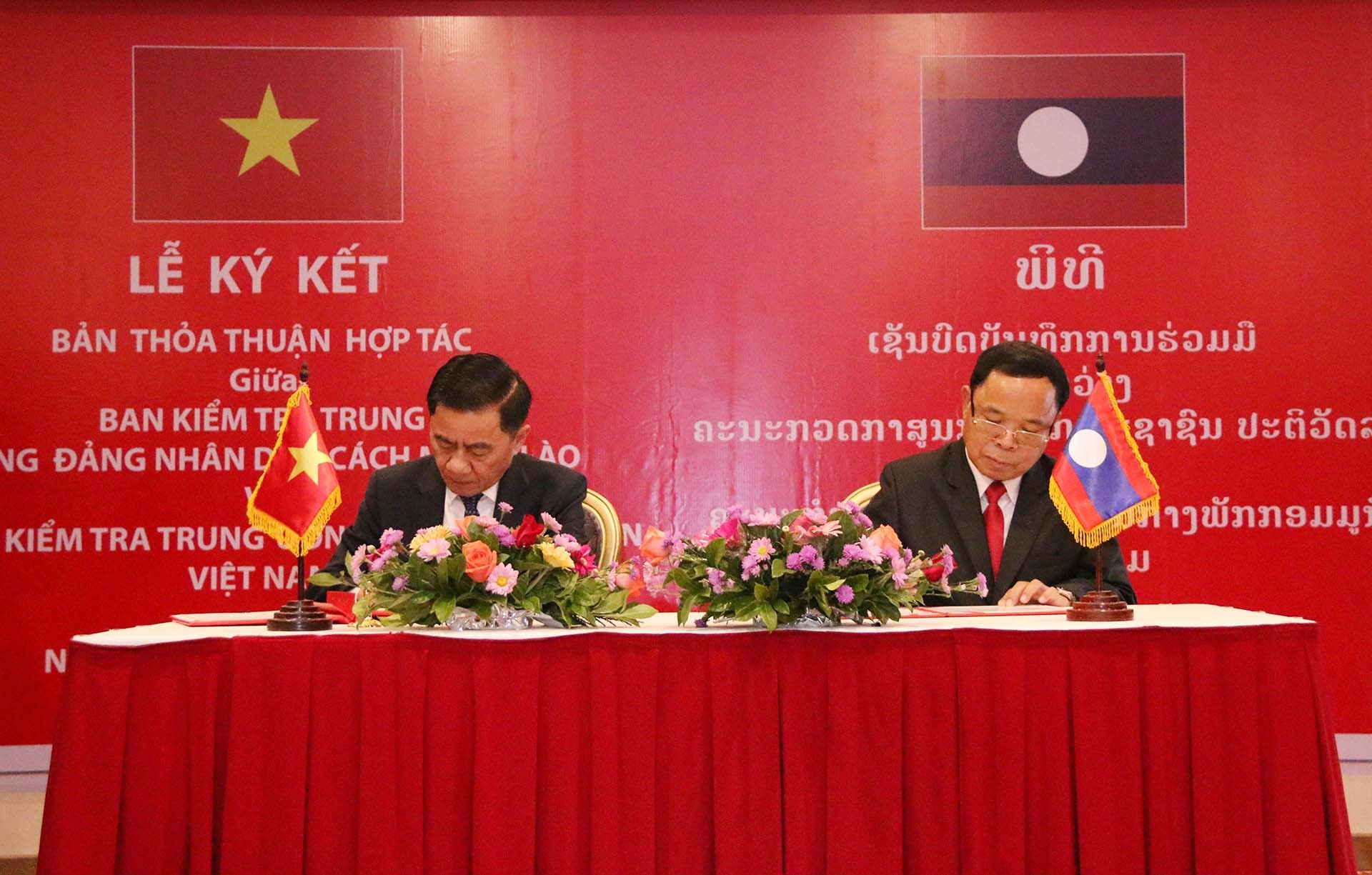Đồng chí Trần Cẩm Tú và đồng chí Khamphanh Phommathath đang ký Thỏa thuận hợp tác giữa hai Cơ quan Kiểm tra Trung ương của hai Đảng giai đoạn 2022 - 2026. (Nguồn: TTXVN)