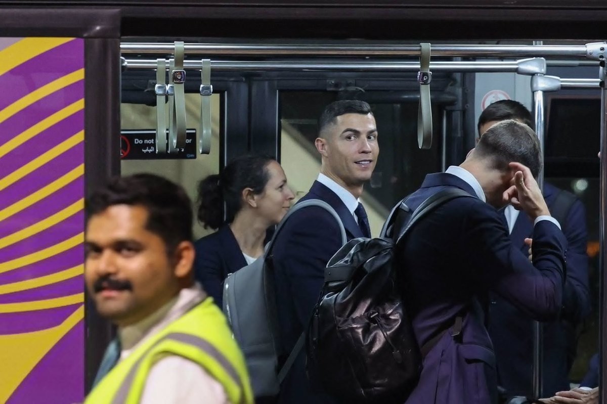 Ronaldo tươi cười khi lên xe buýt rời máy bay tại sân bay Hamad (Ảnh: Getty).