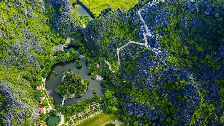 Walking from the foot of the mountain to the top on more than 400 stone steps is an interesting experience and quite a challenge for visitors to the Tam Coc - Bich Dong scenic spot. (Photo: VNA)