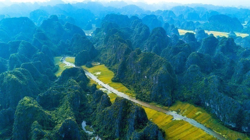 While boating along the romantic river, through limestone mountains, visitors can admire charming rice fields on both banks. (Photo: VNA)