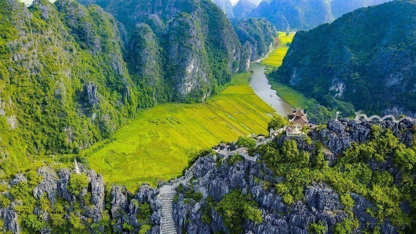 On the top of a local mountain is a statue of Quan Am Buddha, while at the foot of the mountain the Ngo Dong River bends and takes visitors under three natural mountain caves. (Photo: VNA)