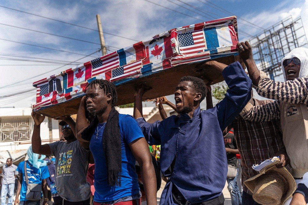 (11.21) Một bộ phận người dân đã xuống đường tuần hành phản đối khả năng Mỹ và Canada can thiệp quân sự vào Haiti. (Nguồn: Reuters)