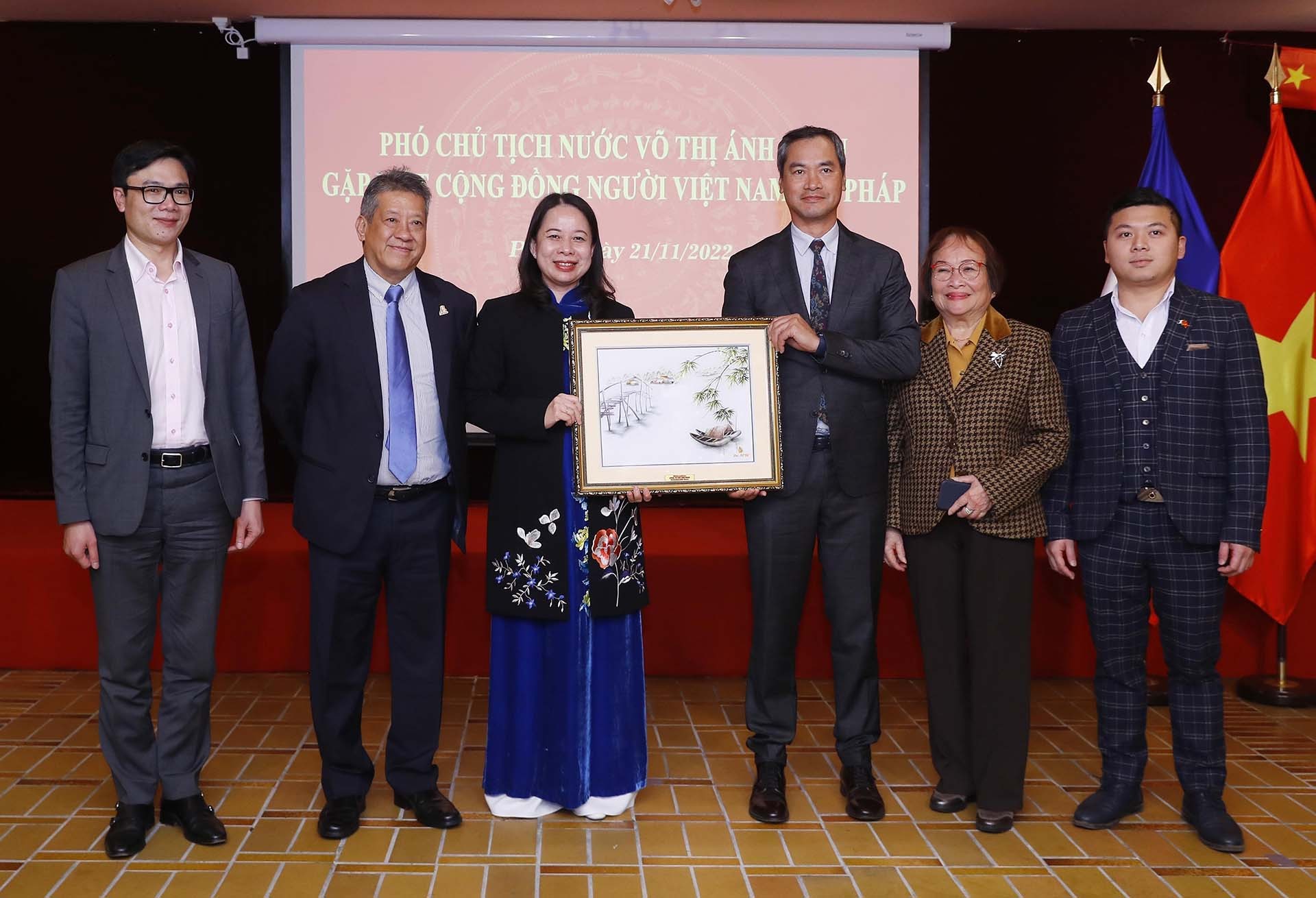 Phó Chủ tịch nước Võ Thị Ánh Xuân trao bức tranh tặng đại diện cộng đồng người Việt Nam tại Pháp. (Nguồn: TTXVN)