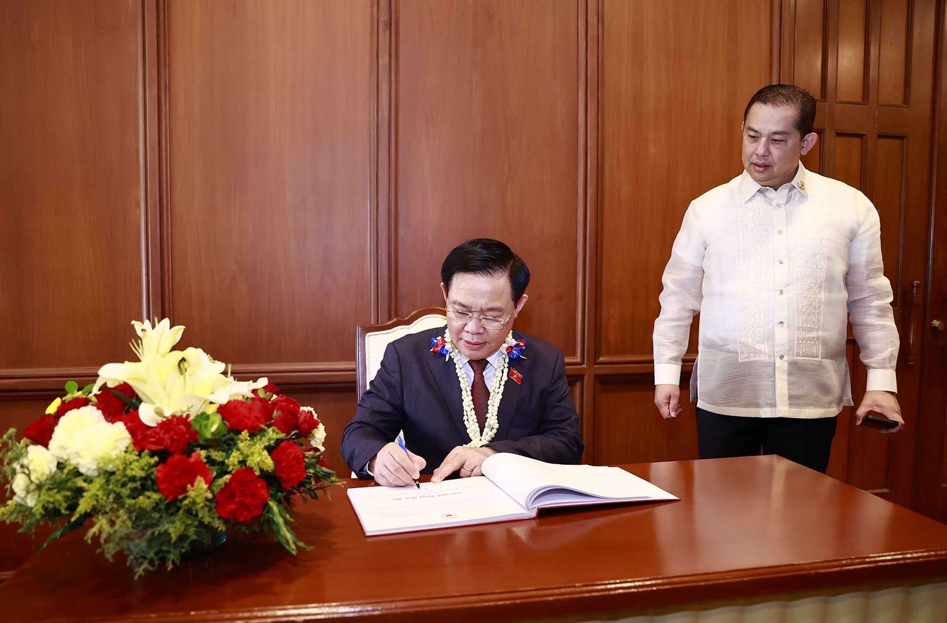Chủ tịch Quốc hội Vương Đình Huệ ghi sổ vàng lưu niệm tại trụ sở Hạ viện Philippines. (Nguồn: TTXVN)