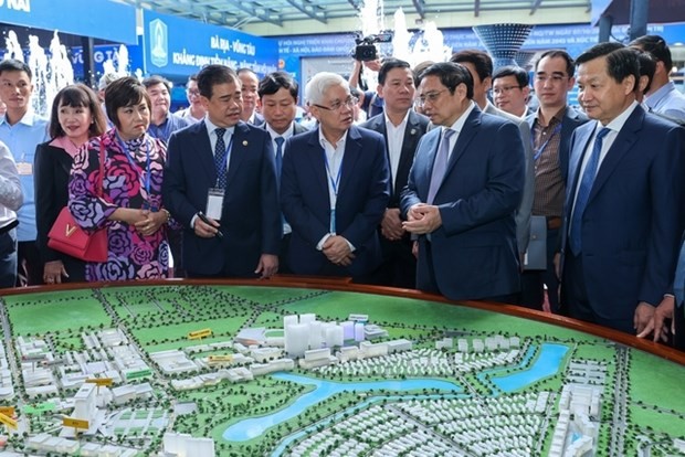 PM Pham Minh Chinh (front, second from right) and officials visit an exhibition on the southeastern region on the sidelines of the conference. (Photo: VNA)