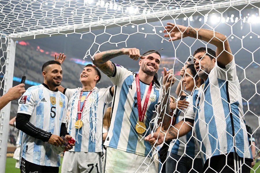 Các cầu thủ Argentina cắt lưới cầu môn làm kỷ niệm sau chung kết.