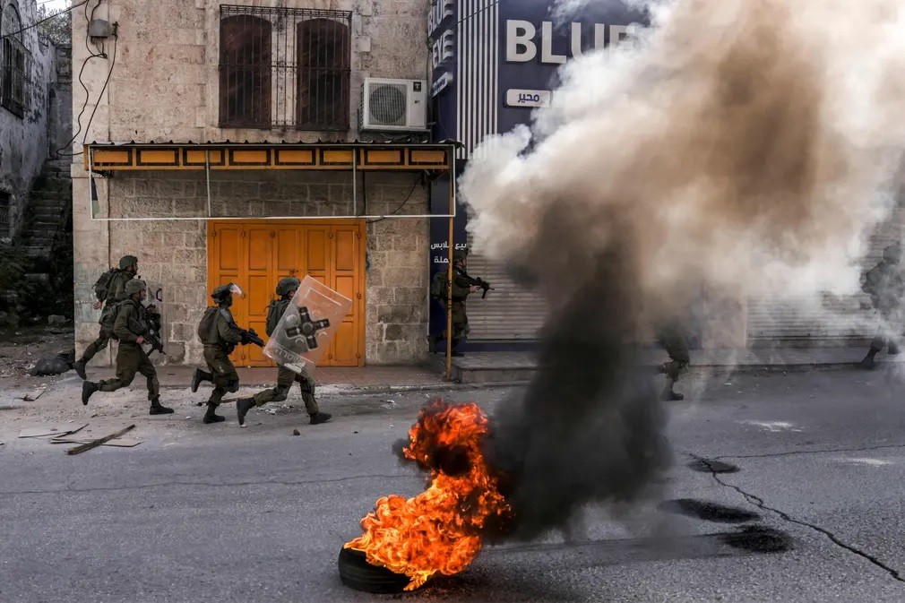 Lính biên phòng Israel dùng lá chắn chống bạo động khi đụng độ với thanh niên Palestine trong cuộc biểu tình ở thành phố Hebron, Bờ Tây. (Nguồn: Getty)