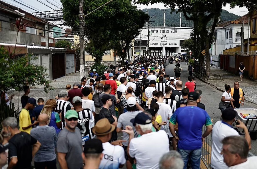 Trước giờ sân mở cửa, hàng nghìn người hâm mộ đổ về Vila Belmiro, xếp hàng dài trên đường phố cạnh sân chờ tới lượt nói lời tiễn biệt Vua bóng đá.