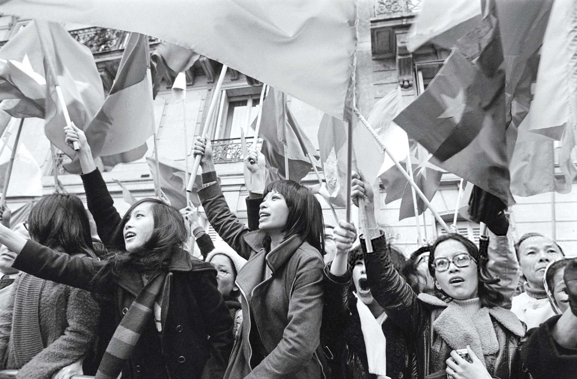 Những người vẫy cờ Việt Nam bên ngoài Trung tâm Hội nghị Quốc tế ở Paris, Pháp, trong ngày Hiệp định Paris được ký kết, ngày 27/01/1973.  (Nguồn: Getty Images)