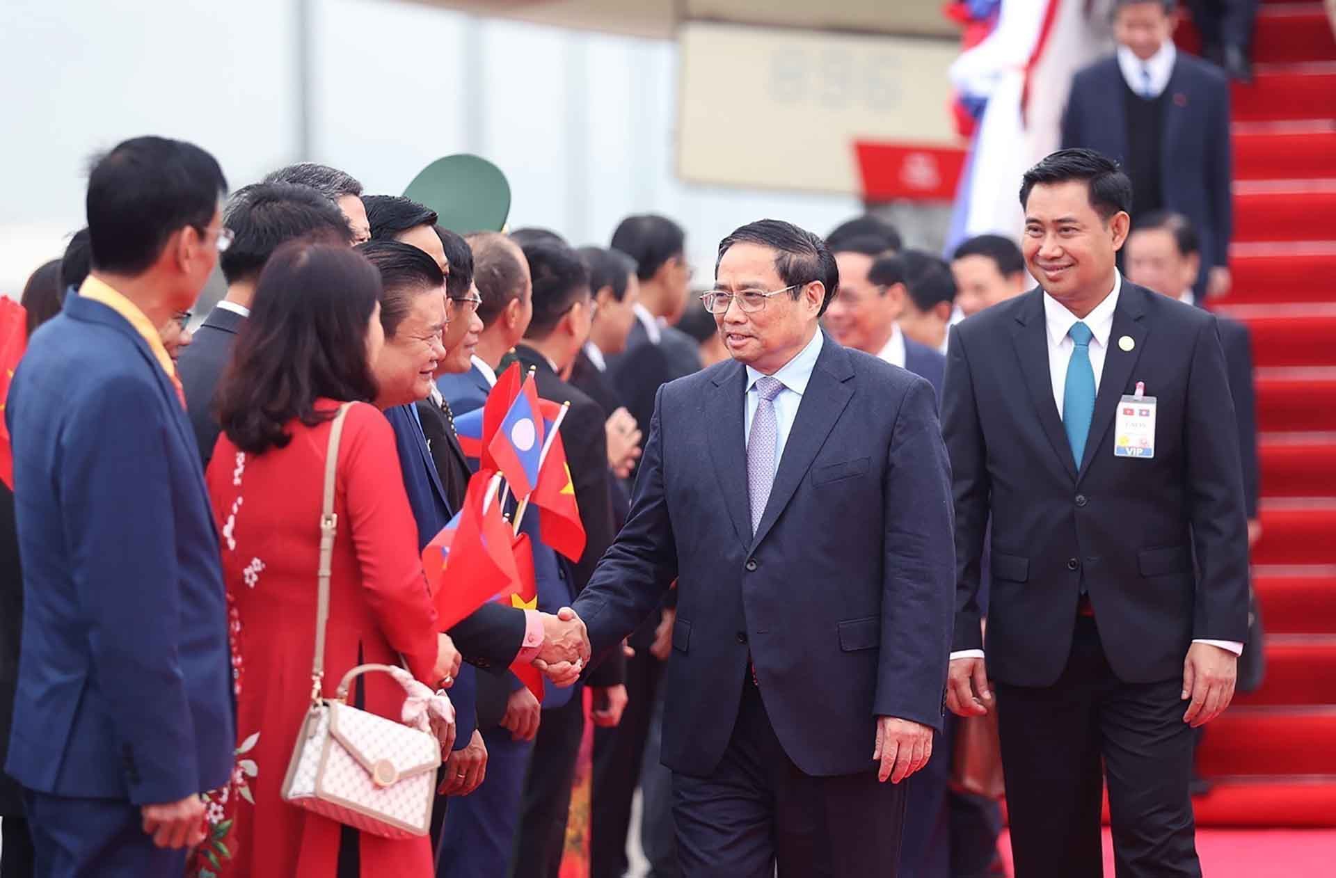 Cán bộ, nhân viên Đại sứ quán và đại diện kiều bào Việt Nam tại Lào đón Thủ tướng Phạm Minh Chính và Đoàn đại biểu cấp cao Việt Nam. (Nguồn: TTXVN)