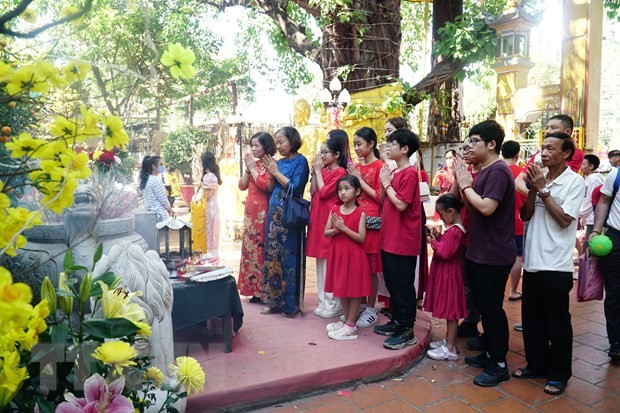 Một gia đình Việt Nam đang sinh sống tại Lào tới lễ chùa đầu năm. (Ảnh: Đỗ Bá Thành/TTXVN)