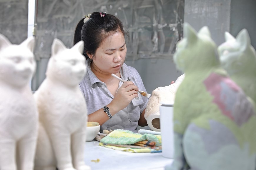 An artisan completes the final steps before putting the ceramic work into the kiln. (Photo: VNP)