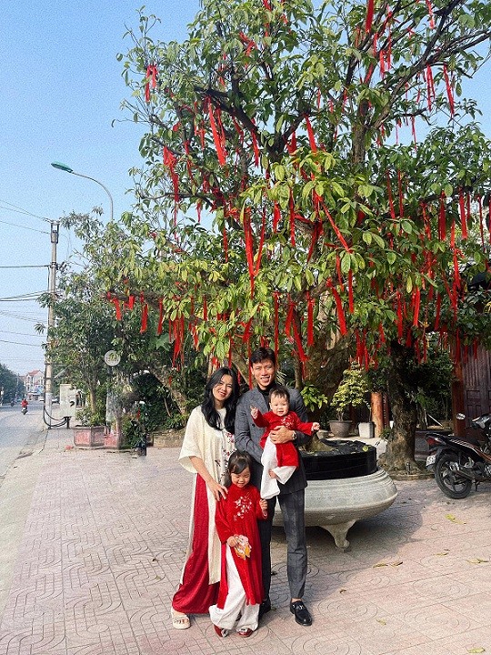 Quế Ngọc Hải cùng bà xã Dương Thùy Phương và hai con gái đi chúc Tết người thân ở Nghệ An. Trung vệ SLNA diện vest lịch lãm trong khi vợ con anh mặc áo dài ton-sur-ton.
