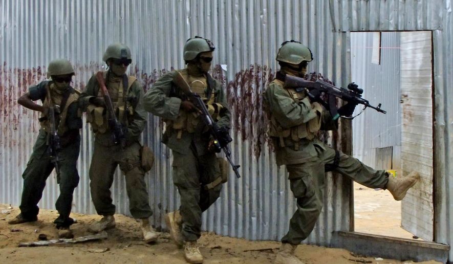 Các binh sĩ Quân đội Quốc gia Somali (SNA) đeo mặt nạ lục soát các ngôi nhà để tìm các chiến binh al-Shabaab trong một chiến dịch ở Ealsha Biyaha, Somalia, vào ngày 2 tháng 6 năm 2012. (Associated Press)