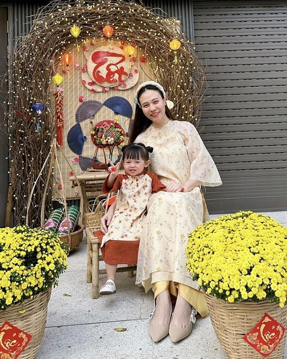 Đàm Thu Trang và con gái diện áo dài của thương hiệu Việt khi đón năm mới. Trang phục hai mẹ con đều có họa tiết hoa lá với màu sắc nhã nhặn, phong cách vintage.