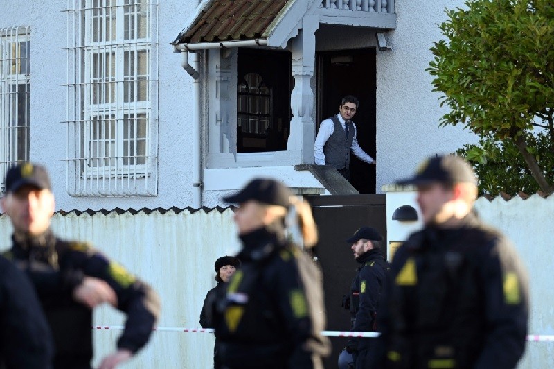 Thổ Nhĩ Kỳ: Cảnh báo du lịch với Mỹ và EU, đòn đáp trả phương Tây từ Ankara. Một người đàn ông nhìn ra khỏi đại sứ quán Thổ Nhĩ Kỳ khi cảnh sát bảo vệ khu vực phía trước đại sứ quán Thổ Nhĩ Kỳ ở Copenhagen, vào ngày 27/1. (Nguồn: AFP)