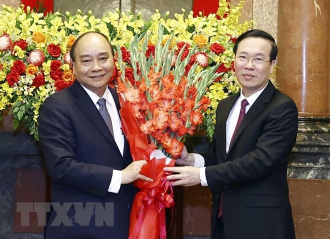 Đồng chí Võ Văn Thưởng, Ủy viên Bộ Chính trị, Thường trực Ban Bí thư tặng hoa nguyên Chủ tịch nước Nguyễn Xuân Phúc.