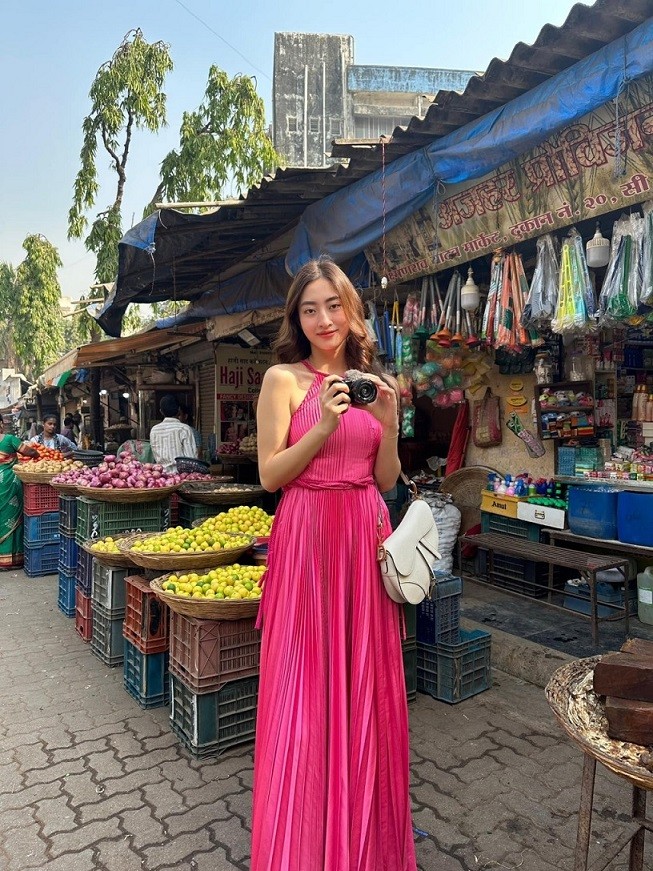 Đầm dài chấm đất của một nhà thiết kế trong nước mang đến cho Hoa hậu Lương Thùy Linh vẻ nữ tính. Cô kết hợp cùng chiếc túi Dior Saddle yêu thích trong một buổi tham quan, mua sắm tại khu chợ ở Ấn Độ.