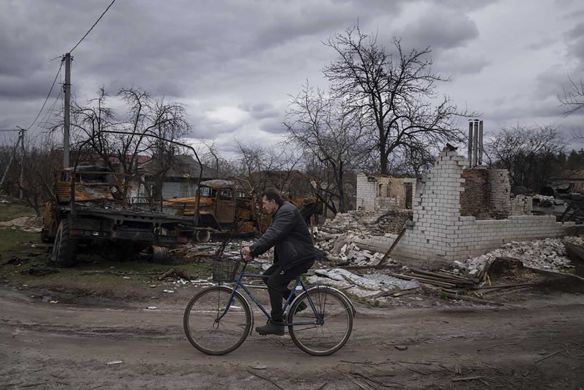 Một năm sau khi bùng phát, xung đột Nga - Ukraine vẫn là bài toán khó của hai nước nói riêng và cộng đồng quốc tế nói chung. Trong ảnh, một người đàn ông đạp xe ngang qua một căn hộ bị phá hủy bởi đạn pháo tại thành phố Dnipro, Ukraine ngày 12/4/2022. (Nguồn: AP) 