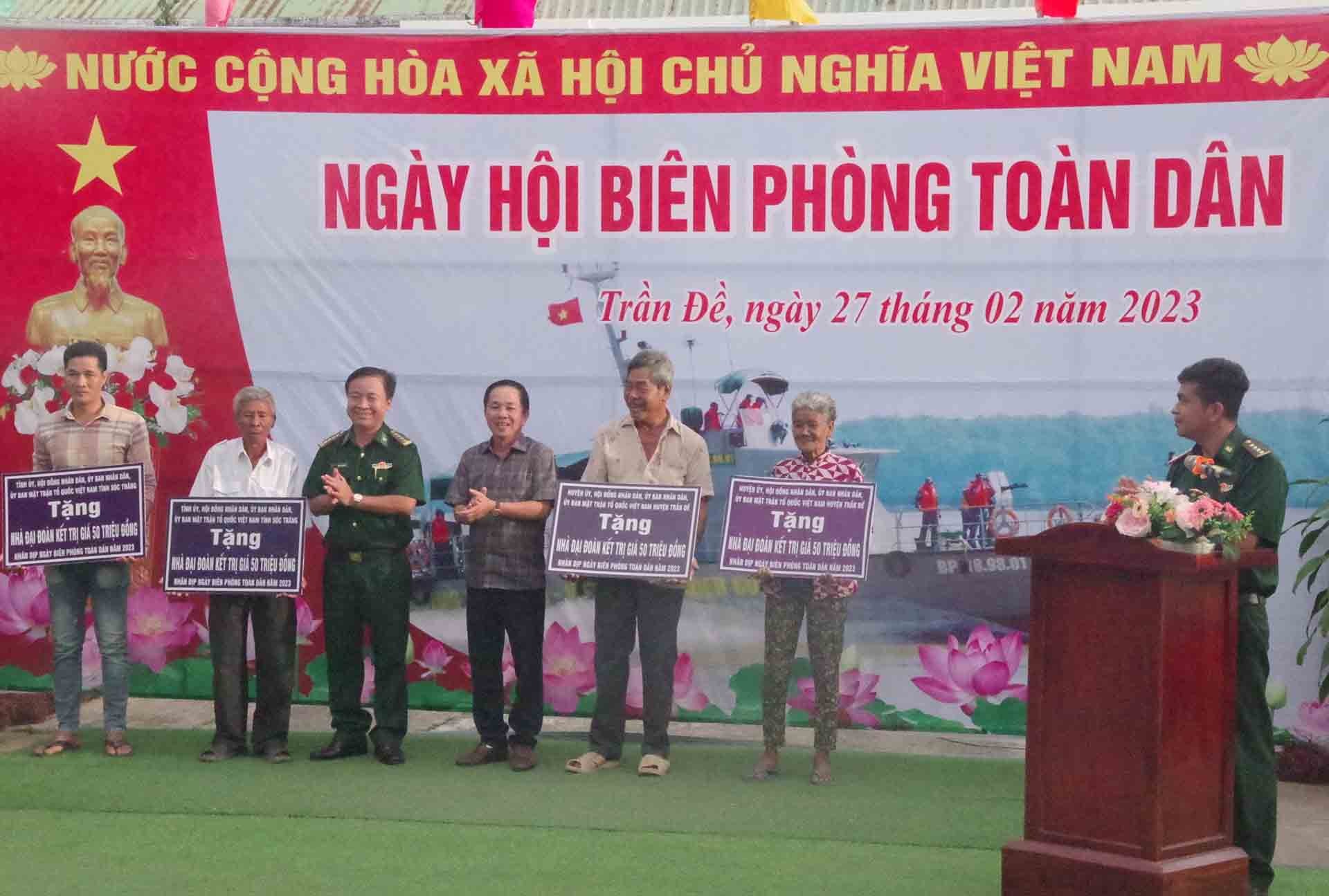Lãnh đạo Bộ đội biên phòng tỉnh và Ủy ban nhân dân huyện Trần Đề trao bảng tượng trưng tặng nhà Đại đoàn kết cho người nghèo khu vực biên giới biển huyện Trần Đề.