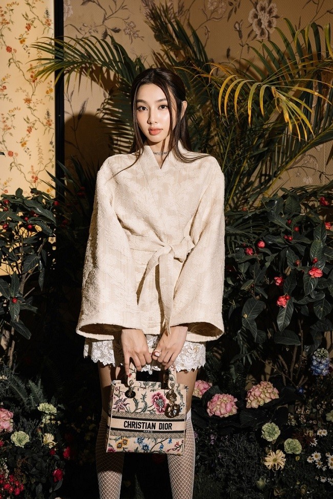 Người đẹp diện kimono jackjet đặc trưng mùa mới kèm quần ren thêu họa tiết mimosa tinh xảo, tạo điểm nhấn bằng tất lưới. Đại diện nhà mốt Dior cho biết chọn Thùy Tiên là nàng thơ vì phong cách năng động, trẻ trung.