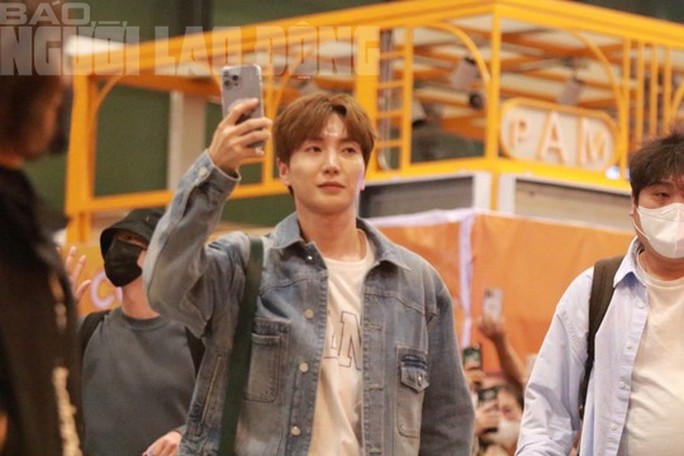 Leeteuk vui vẻ cầm điện thoại quay lại cảnh người hâm mộ tại sân bay Tân Sơn Nhất. Ảnh: Thanh Thảo