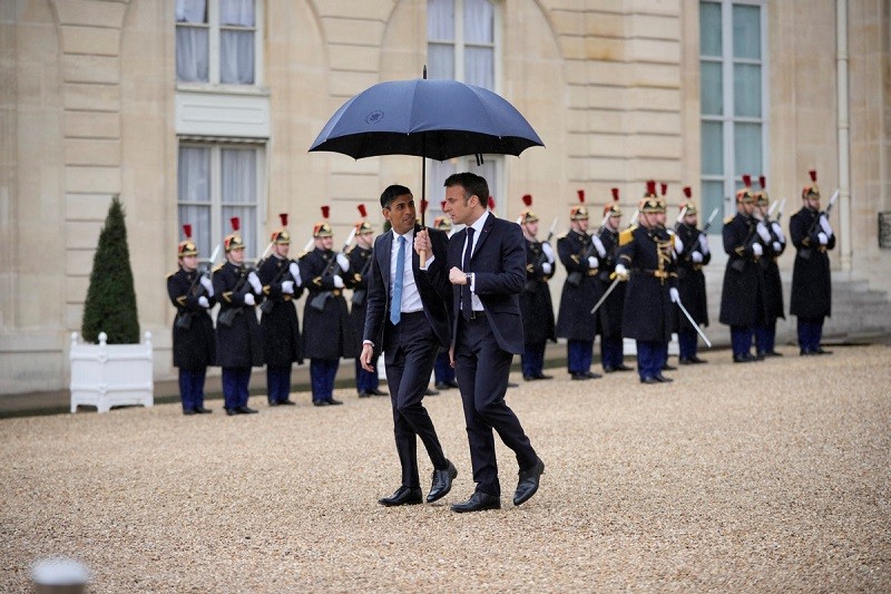 Tổng thống Pháp Emmanuel Macron, dùng ô để bảo vệ Thủ tướng Anh Rishi Sunak sau hội nghị thượng đỉnh Pháp-Anh tại Cung điện Elysee ở Paris, Pháp, Thứ Sáu, ngày 10 tháng 3 năm 2023