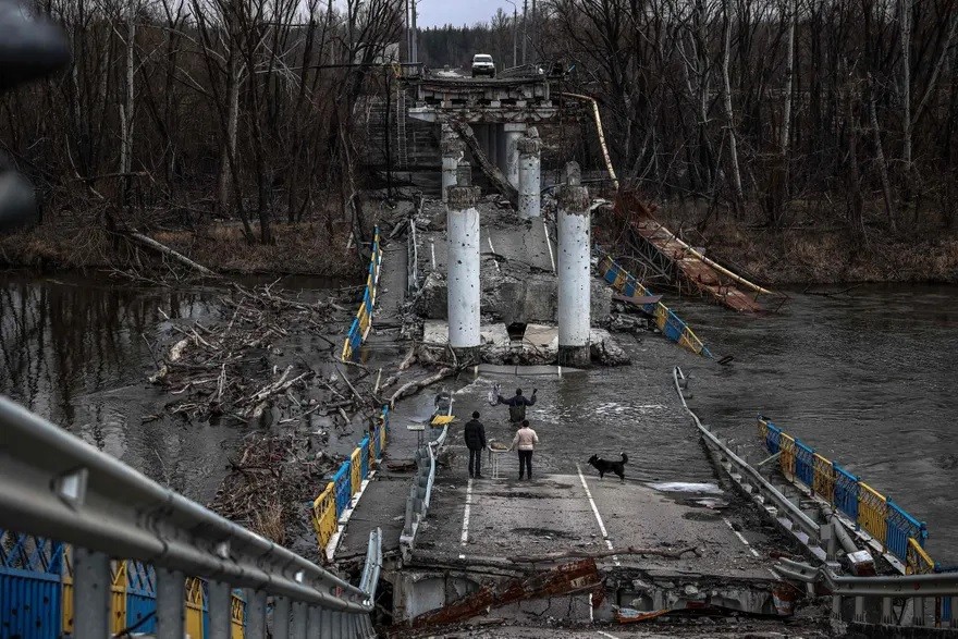 Người dân băng qua sông Siversky Donets ở Bohorodychne, Ukraine trên cây cầu đã bị phá hủy để nhận lương thực cứu trợ. (Nguồn: Getty)