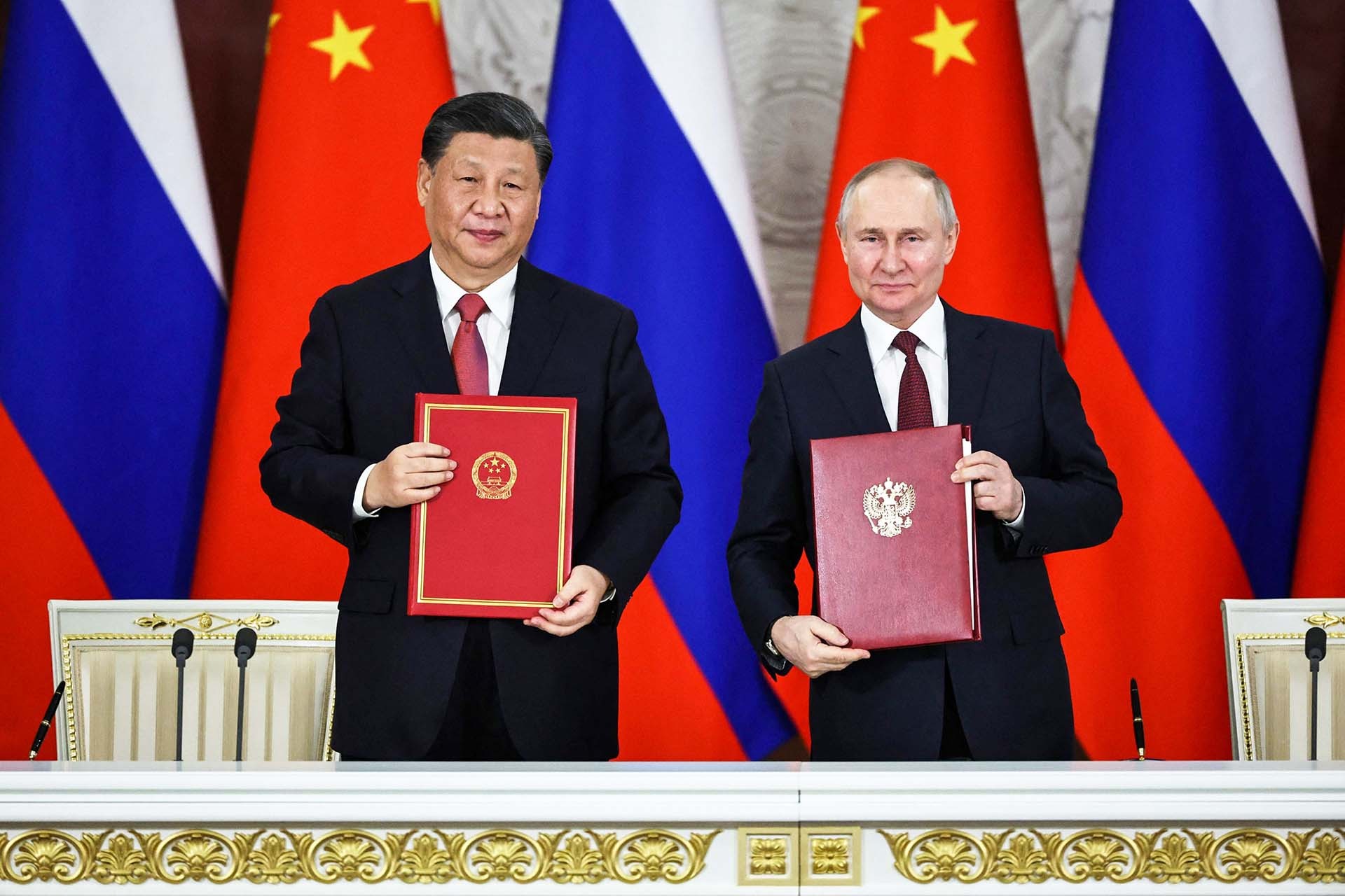 Chủ tịch Trung Quốc Tập Cận Bình (trái) và Tổng thống Nga Vladimir Putin ký kết văn bản sau hội đàm ngày 21/3 tại Moscow.  (Nguồn: Getty Images)