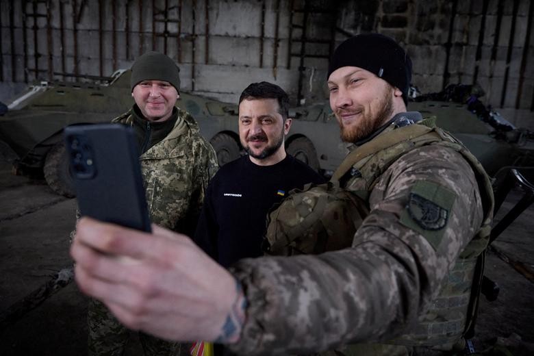 Tổng thống Ukraine Volodymyr Zelensky chụp ảnh cùng các quân nhân nước này tại một vị trí gần tiền tuyến ở vùng Donetsk, Ukraine, ngày 22/3. (Nguồn: Reuters)