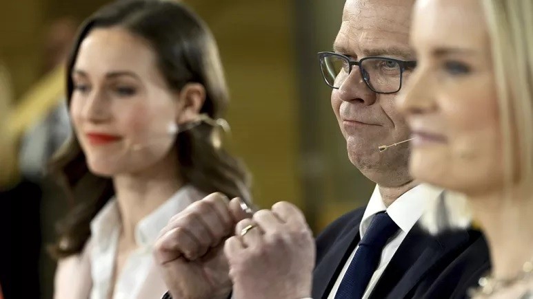 Chủ tịch SDP Sanna Marin, trái, và chủ tịch đảng Phần Lan Riikka Purra, phải, nhìn chủ tịch Đảng Liên minh Quốc gia Petteri Orpo cổ vũ trong cuộc bầu cử quốc hội. AP)