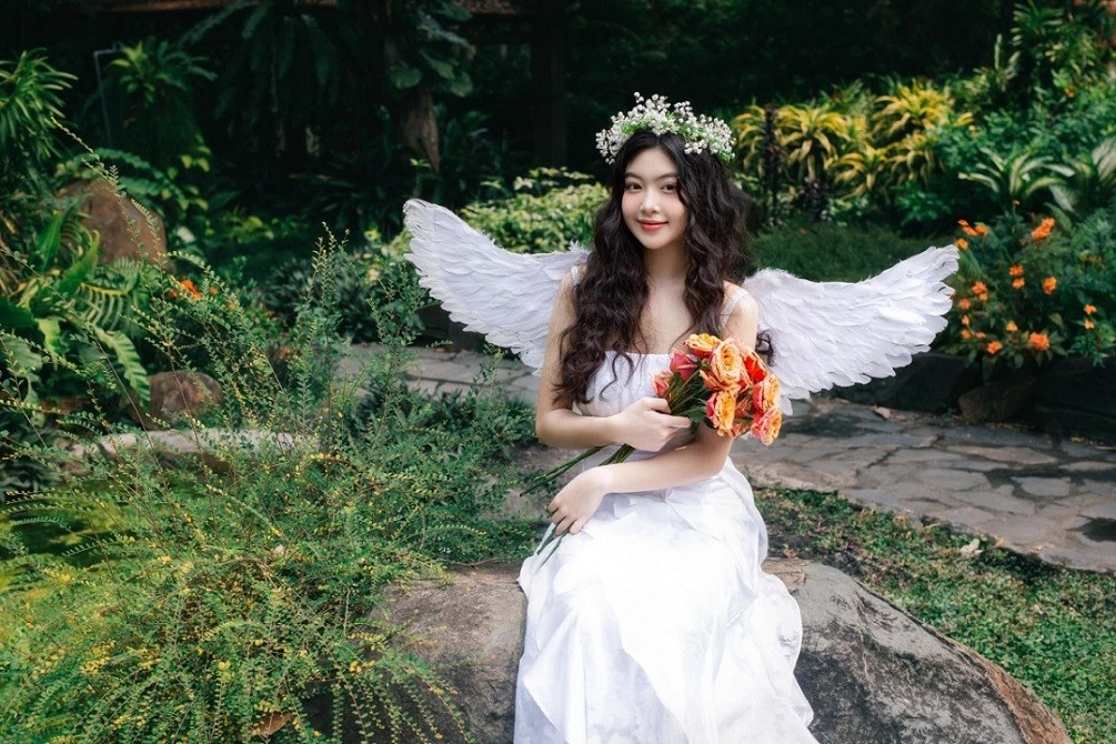 Con gái lớn nhà MC Quyền Linh - doanh nhân Dạ Thảo đeo cánh thiên thần kết hợp váy hai dây trắng và vương miện hoa.