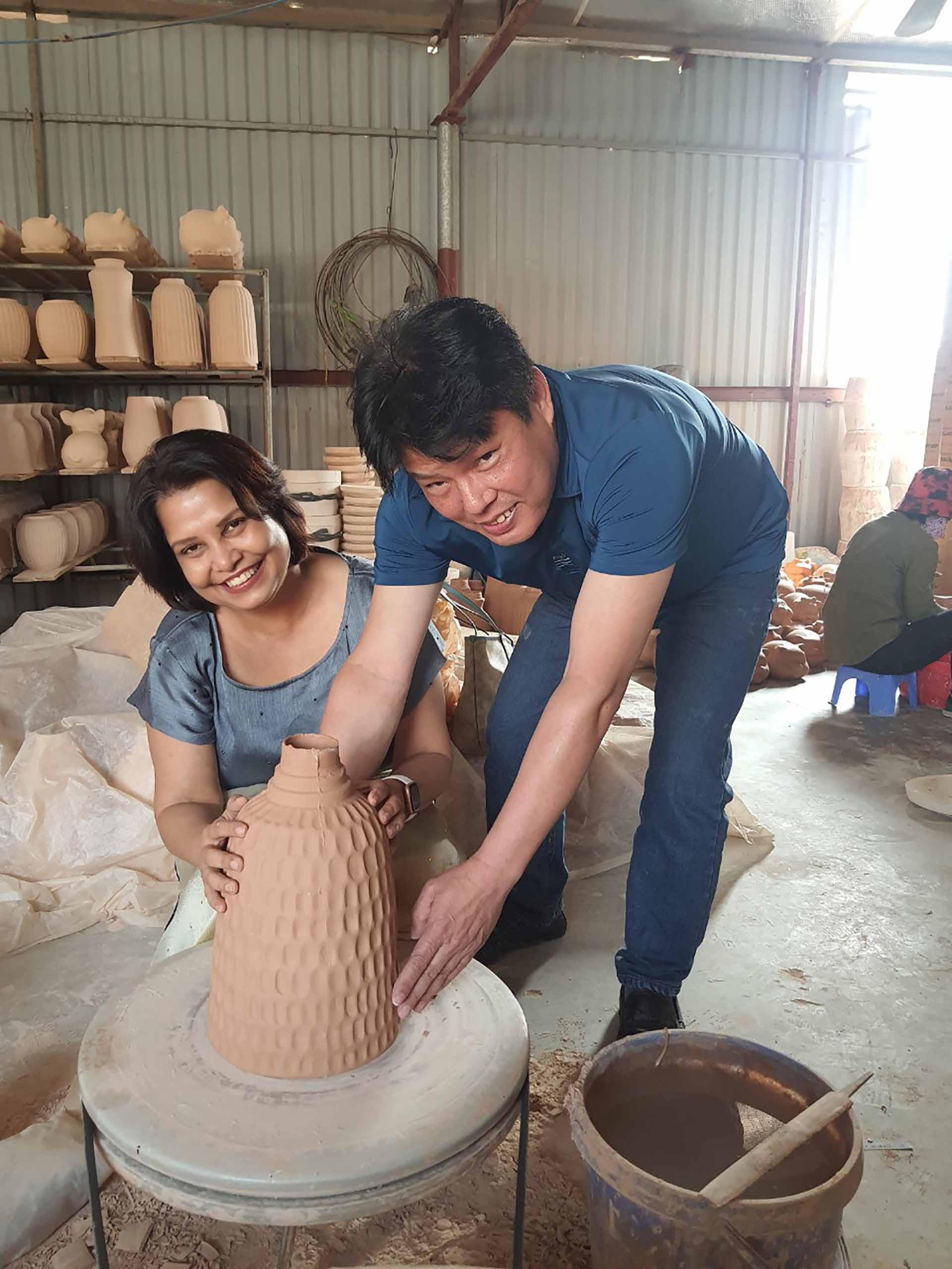 Ông Nguyễn Văn Dũng hướng dẫn du khách người Ấn Độ, bà Rashmi trải nghiệm làm gốm. (Ảnh: M.H)