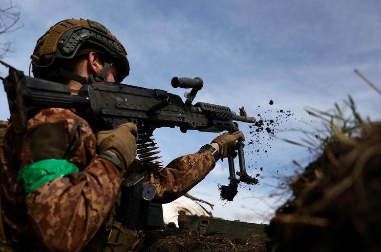 Quân nhân Ukraine, Naza, 21 tuổi, chỉ huy từ Lữ đoàn cơ giới số 28, chỉnh lại vị trí khẩu súng máy trong một cuộc đọ súng tại tiền tuyến ở khu vực Bakhmut, Ukraina, ngày 5/4. (Nguồn: Reuters)