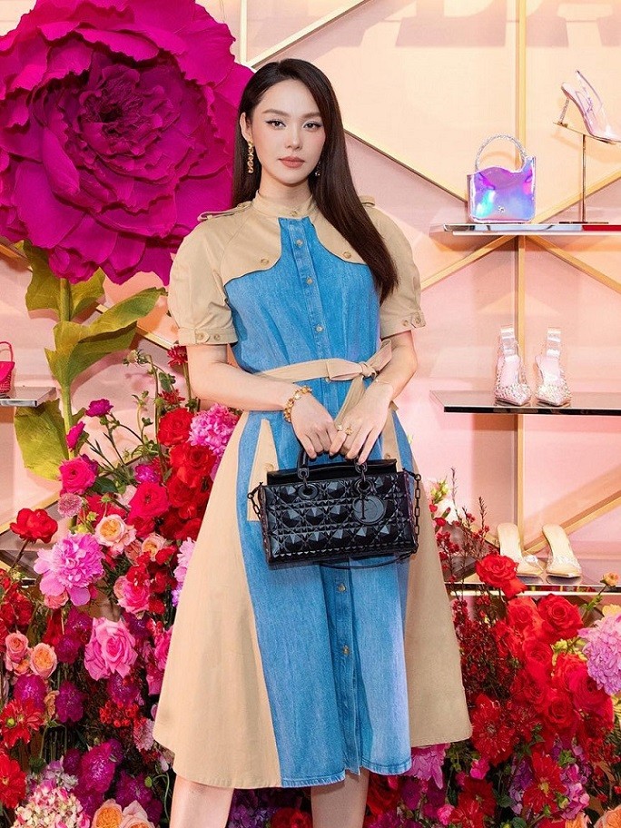 Tham dự sự kiện sau khi trở về từ Hàn Quốc, Minh Hằng chọn mẫu váy denim thắt đai eo nhẹ nhàng. Cô tạo điểm nhấn cho tổng thể bằng chiếc túi Dior D-Joy gam đen khoảng 120 triệu đồng.