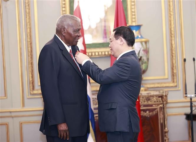 National Assembly Chairman Vuong Dinh Hue presents the Ho Chi Minh Medal to President of the Cuban National Assembly Esteban Lazo Hernandez. Photo: Doan Tan - VNA