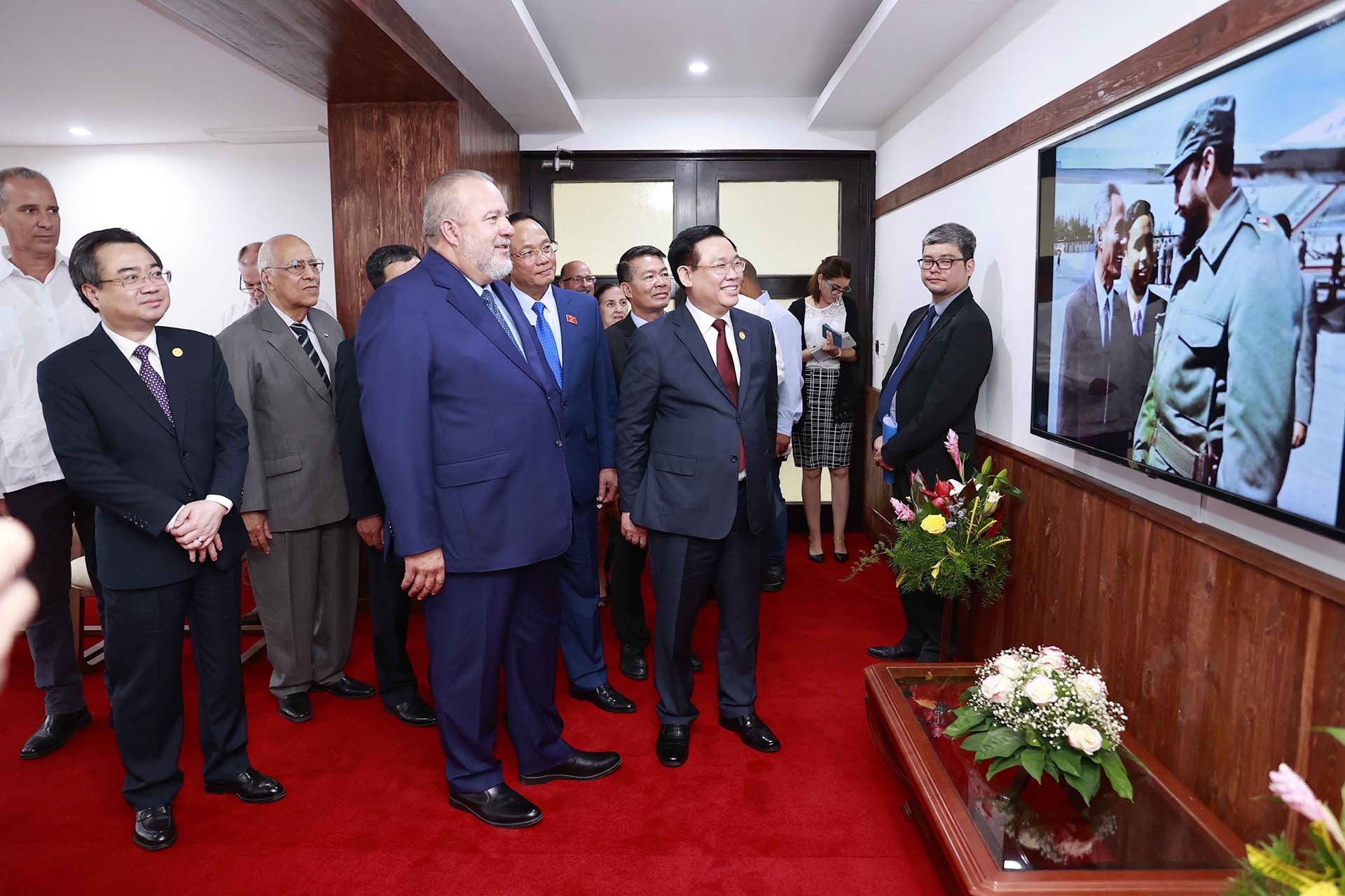 Chủ tịch Quốc hội Vương Đình Huệ và Thủ tướng Cộng hòa Cuba Manuel Marrero Cruz xem ảnh tư liệu về quan hệ Việt Nam-Cuba. (Nguồn: TTXVN)