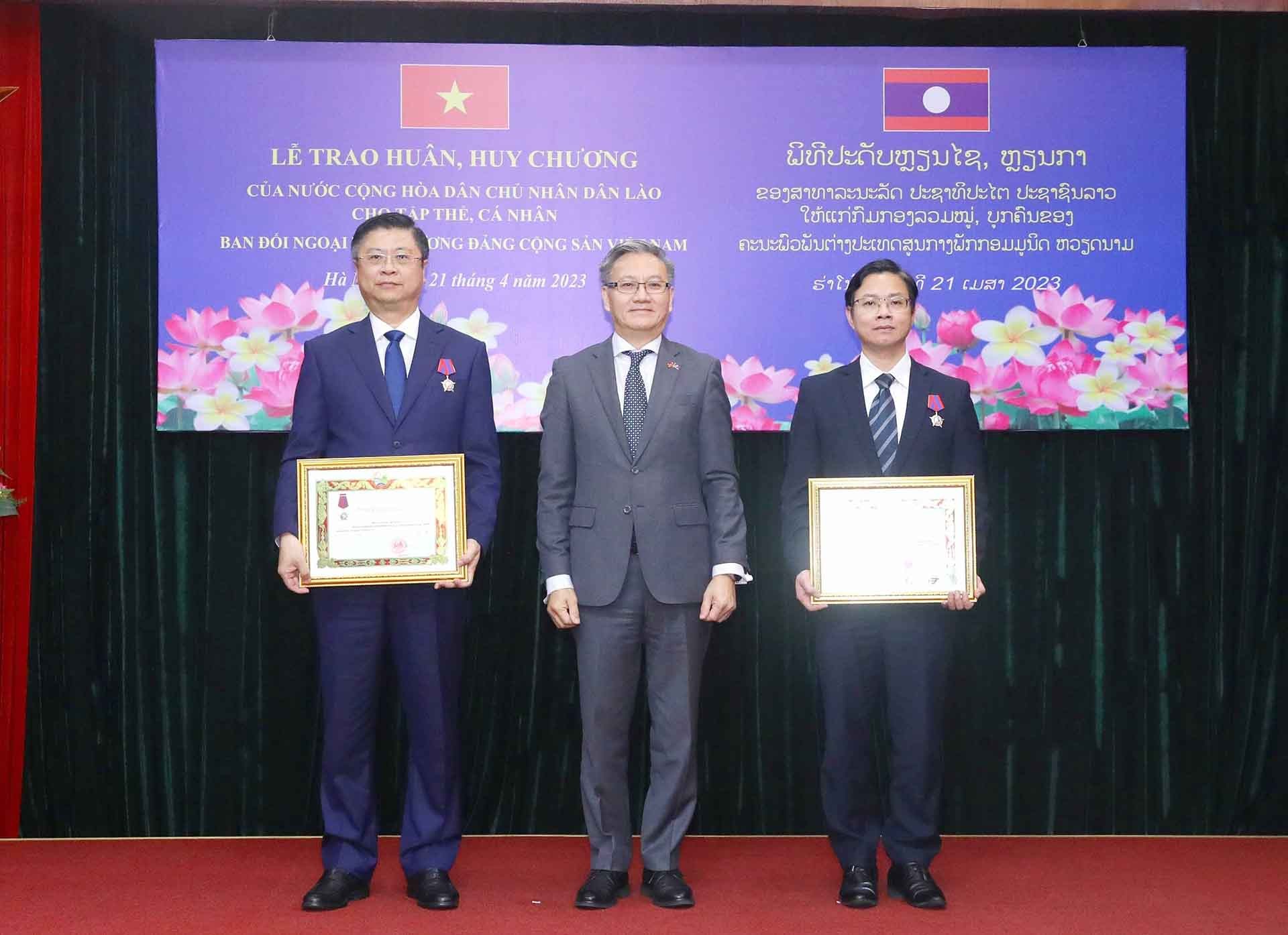 Trưởng Ban Đối ngoại Đảng Nhân dân Cách mạng Lào Thongsavanh Phomvihane trao Huân chương Tự do Hạng Ba của Chủ tịch nước Lào cho các cá nhân có thành tích xuất sắc. (Nguồn: TTXVN)