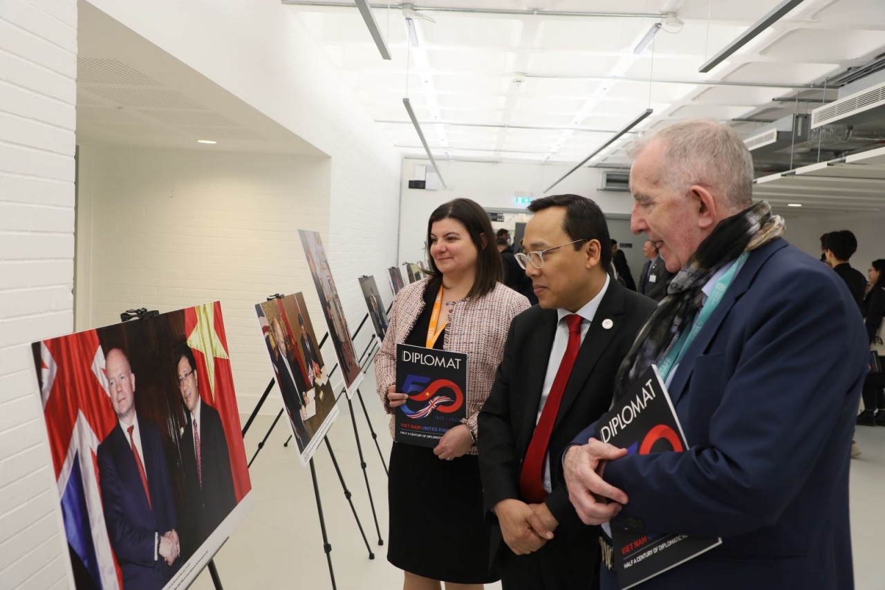 Đại sứ Nguyễn Hoàng Long và các đại biểu tham quan triển lãm ảnh kỷ niệm 50 năm quan hệ ngoại giao Việt Nam - Anh tại LSBU. Ảnh: Phong Hà/TTXVN