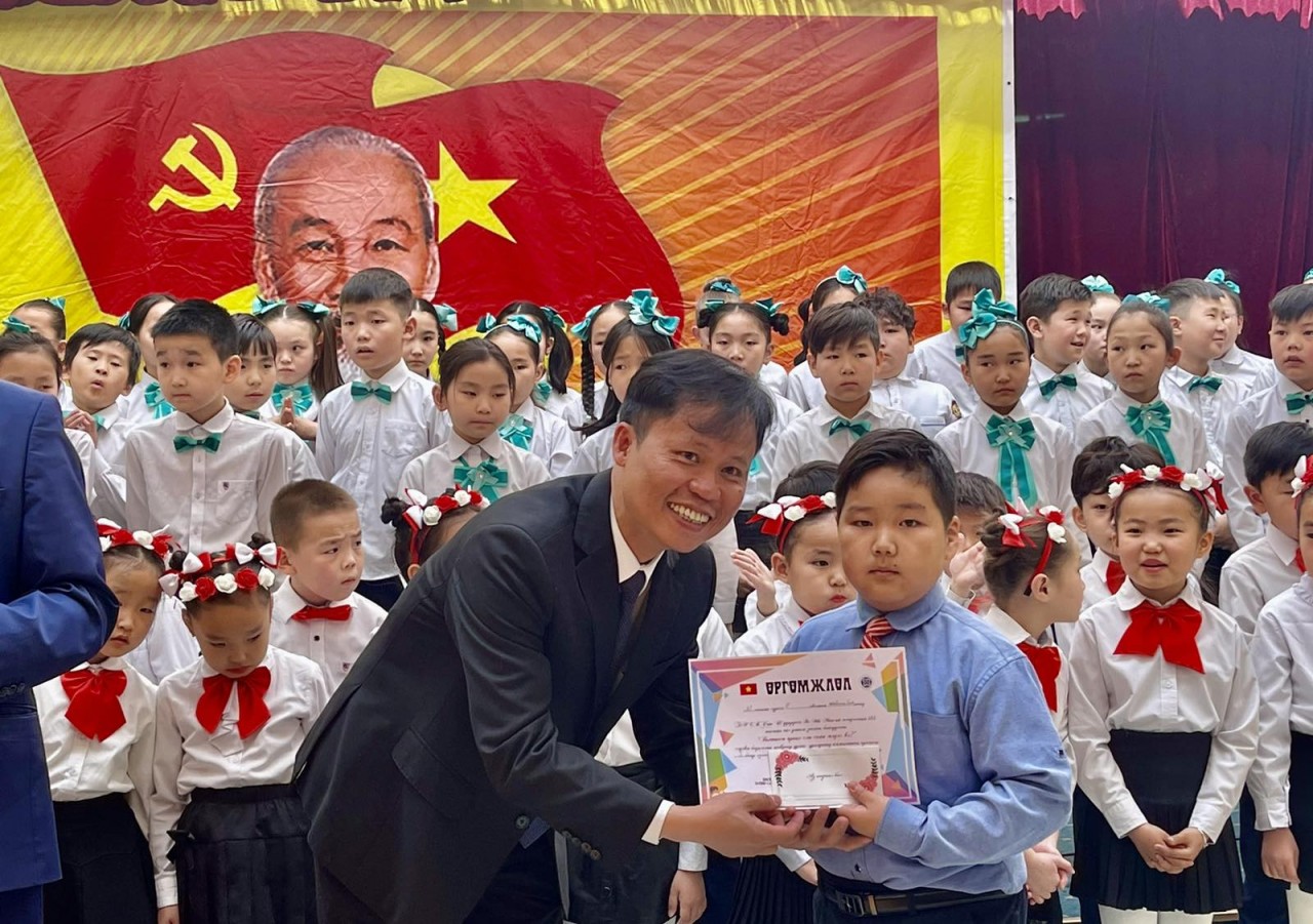 Đại sứ Doãn Khánh Tâm tặng phần thưởng cho học sinh đoạt giải xuất sắc trong cuộc thi.