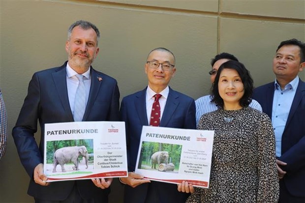 Đại sứ Vũ Quang Minh cùng Phu nhân Nguyễn Minh Hạnh và Thị trưởng thành phố Cottbus Tobias Schick (trái) nhận Giấy Chứng nhận bảo trợ cho voi tại Vườn thú Cottbus. (Nguồn: TTXVN)