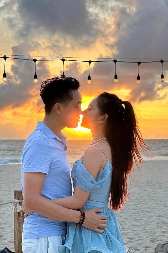 Vợ chồng Sara Lưu - Dương Khắc Linh trao môi hôn dưới ánh hoàng hôn ở biển Phuket, Thái Lan. Nữ ca sĩ cho biết ông xã bí mật tổ chức tiệc mừng kỷ niệm bốn năm ngày cưới, nói dối với cô cần quay video hát live nên nhờ cô diện đầm 'bánh bèo'.