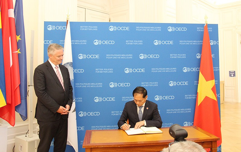 Bộ trưởng Ngoại giao Bùi Thanh Sơn ghi sổ lưu niệm tại trụ sở OECD.  (Ảnh: Bảo Chi)