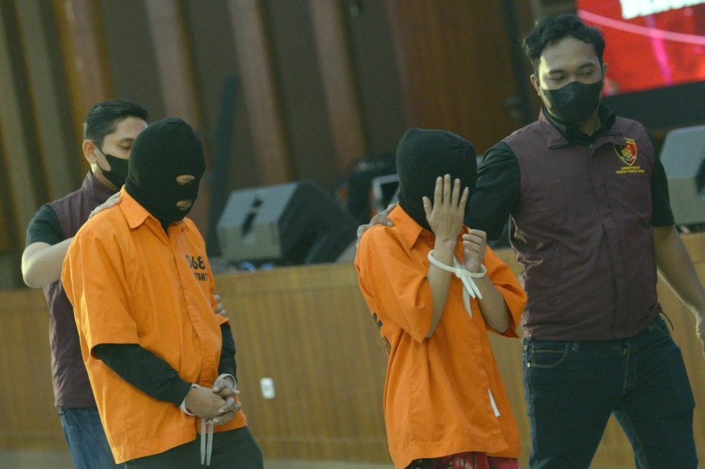 Hai nghi phạm liên quan đến nạn buôn người Indonesia sang Myanmar xuất hiện tại đơn vị điều tra tội phạm của cảnh sát ở Jakarta vào ngày 16/5/2023. (Ảnh: Joanito De Saojoao)
