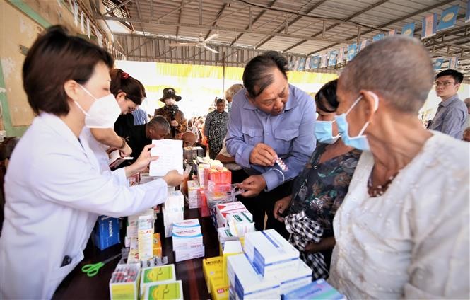 Người dân Campuchia xúc động khi được các y, bác sĩ Việt Nam khám bệnh, cấp thuốc miễn phí. (Nguồn: TTXVN)