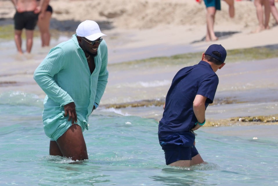 Trong chuyến đi chơi hôm 21/6, Usain Bolt mặc đồ linen màu xanh. Khi từ thuyền xuống biển, chân chạy lừng danh một thời vén quần hết cỡ để không bị ướt.