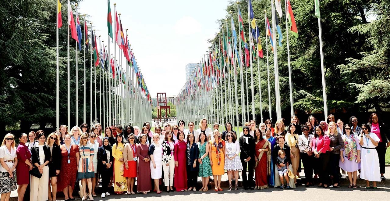 Đại sứ Lê Thị Tuyết Mai, Trưởng Phái đoàn Việt Nam tại Geneva và các cán bộ nữ Phái đoàn cùng nhiều nữ Đại sứ và cán bộ ngoại giao nữ các nước tại Geneva đứng trước hàng cờ các quốc gia thành viên LHQ tại trụ sở LHQ tại Geneva. (Nguồn: TTXVN)